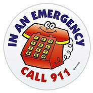 Circular cartoon-style sticker with a smiling red rotary phone character in the center. The text around it reads: “IN AN EMERGENCY CALL 911” in blue and red capital letters.
