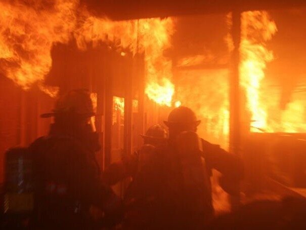 Firefighters entering a burning building